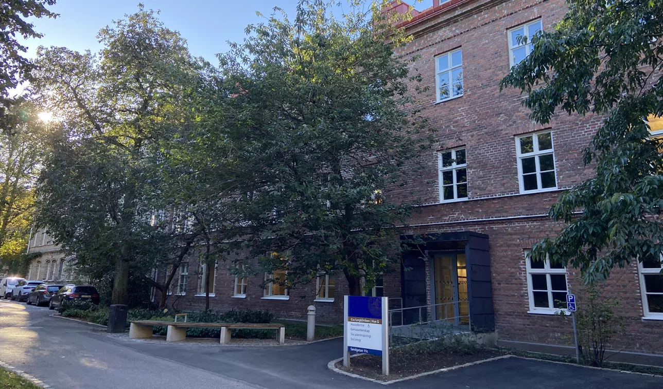 A red brick building surrounded by trees.